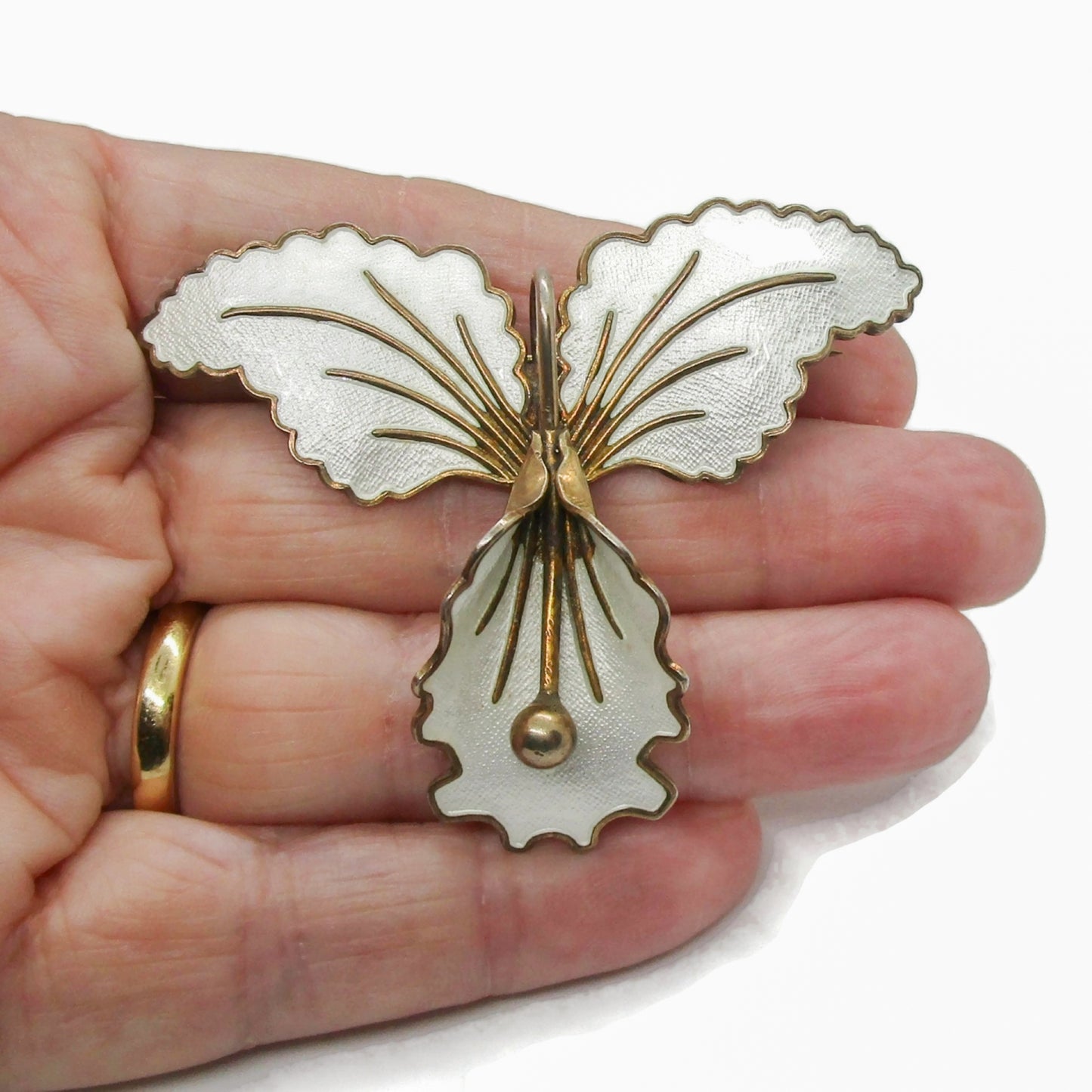 Aksel Holmsen Norway sterling silver gilt and white enamel orchid brooch shown being held in a hand
