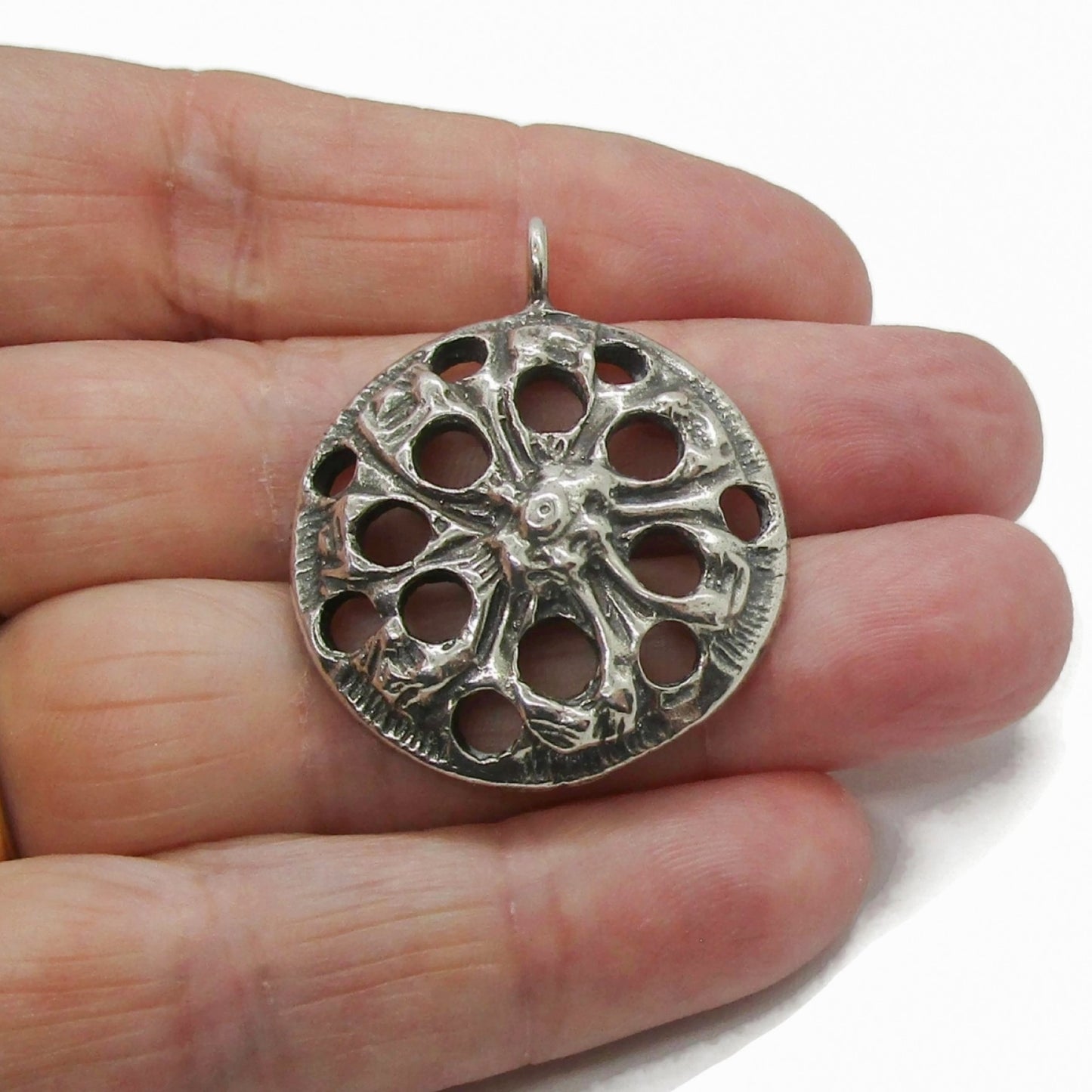 A silver Viking replica pendant by G Dunker Norway held in a hand