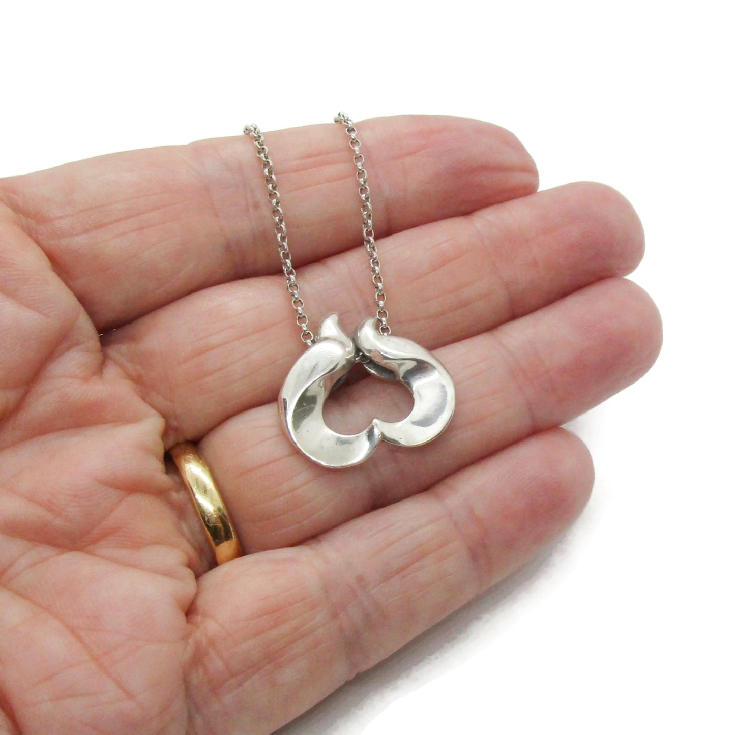 Georg Jensen sterling silver pendant of the year for 1995 designed by Allan Scharff shown held in a hand
