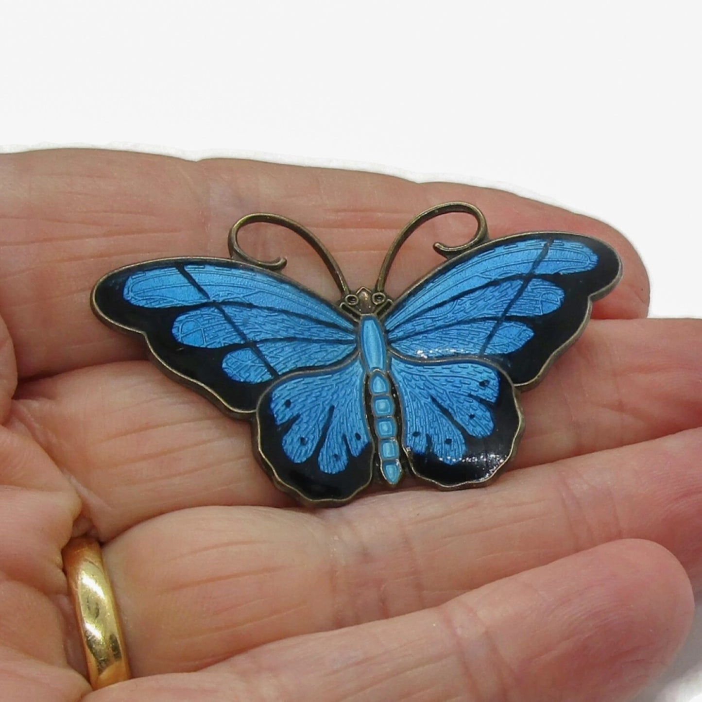 Hroar Prydz blue enamel and sterling silver butterfly brooch shown held in a hand