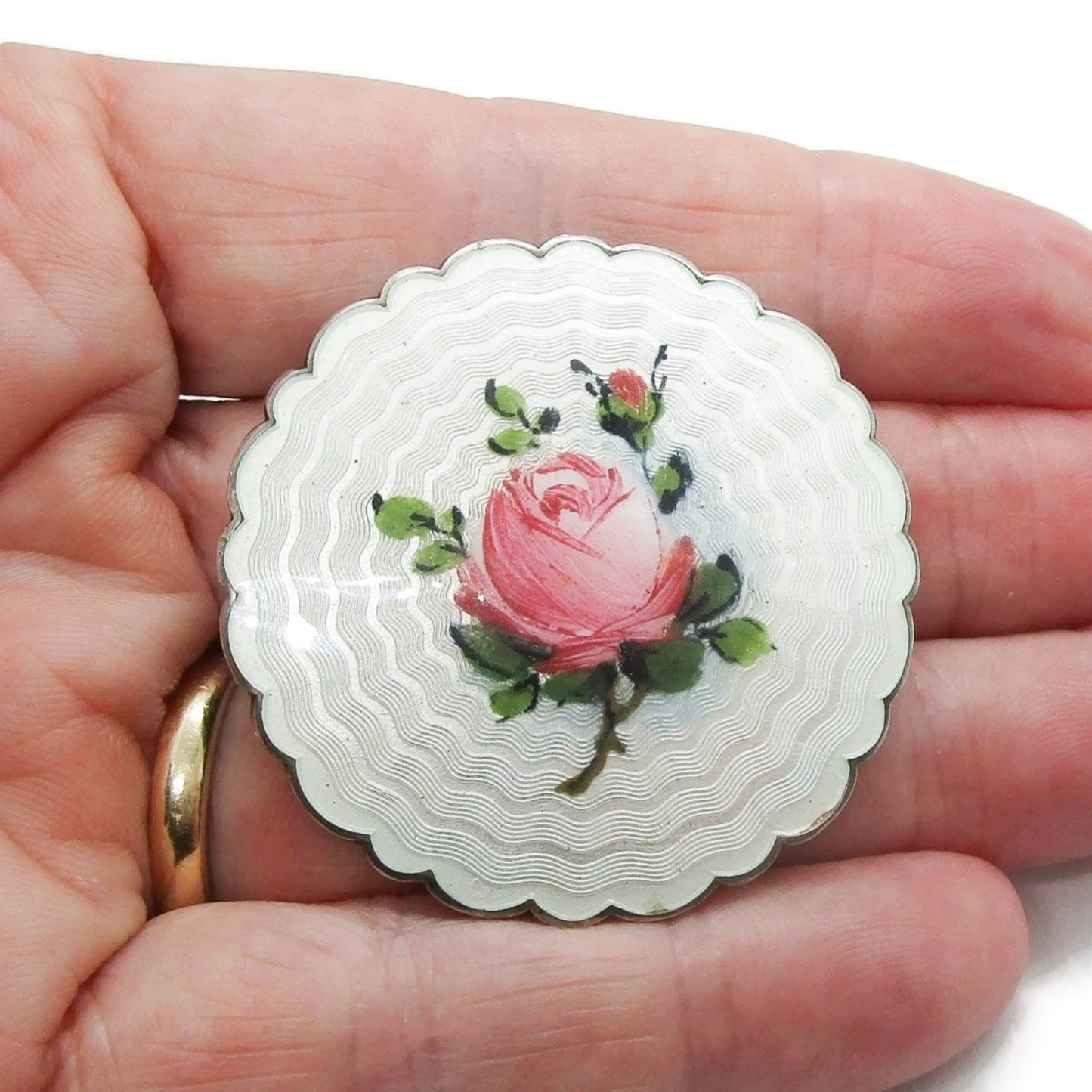 An Ivar Holth Norway large pink rose sterling silver enamel brooch held in a hand