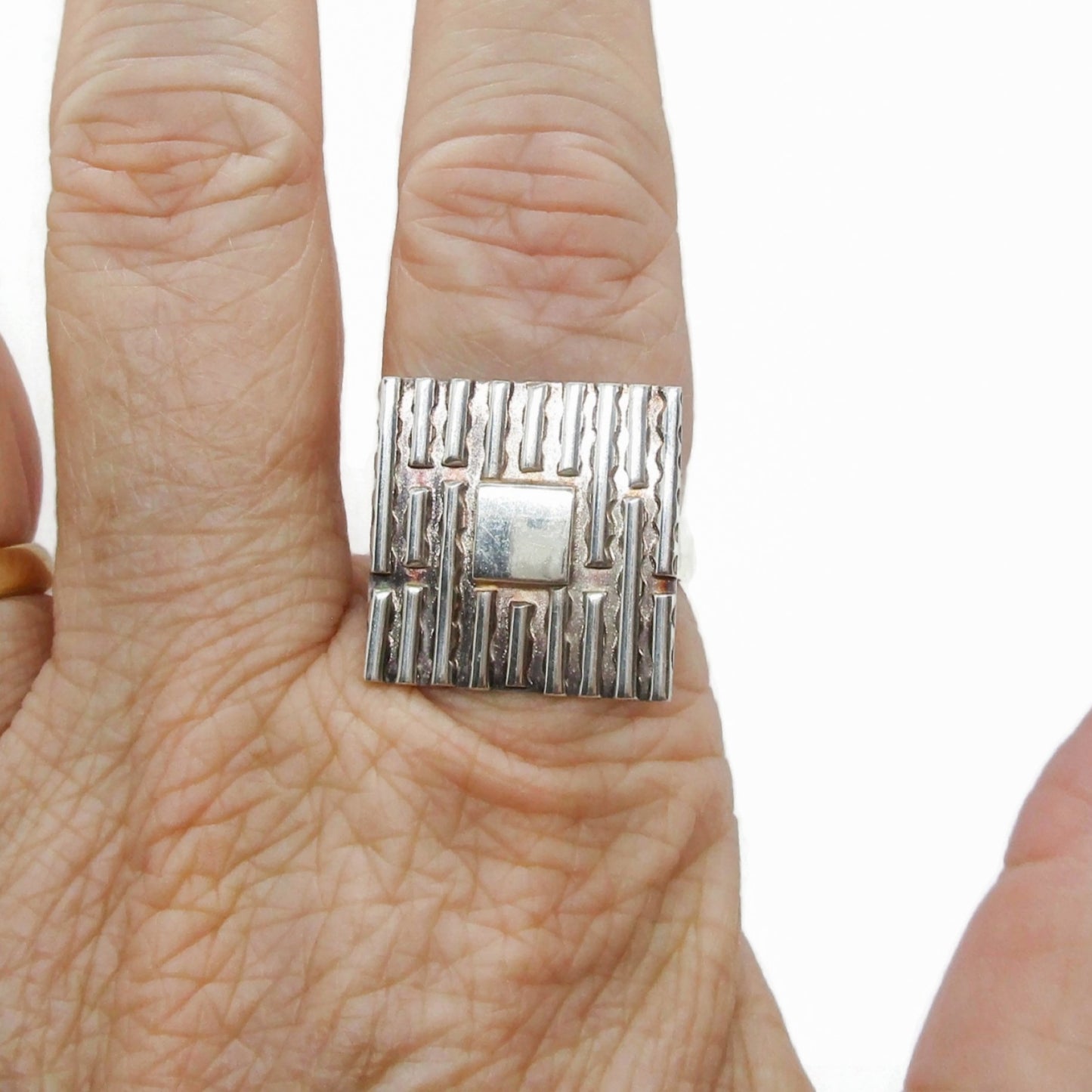 A square statement sterling silver ring by LED shown worn on a hand