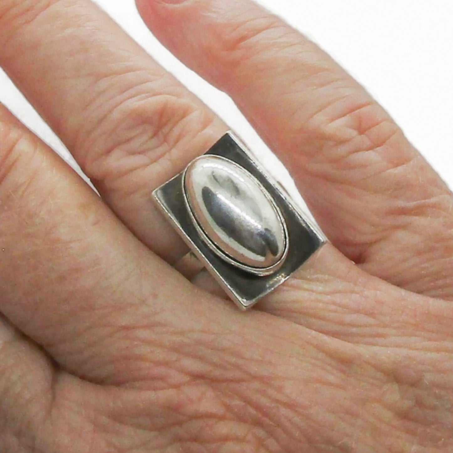 A Niels Erik From Denmark sterling silver cabochon ring shown worn on a hand