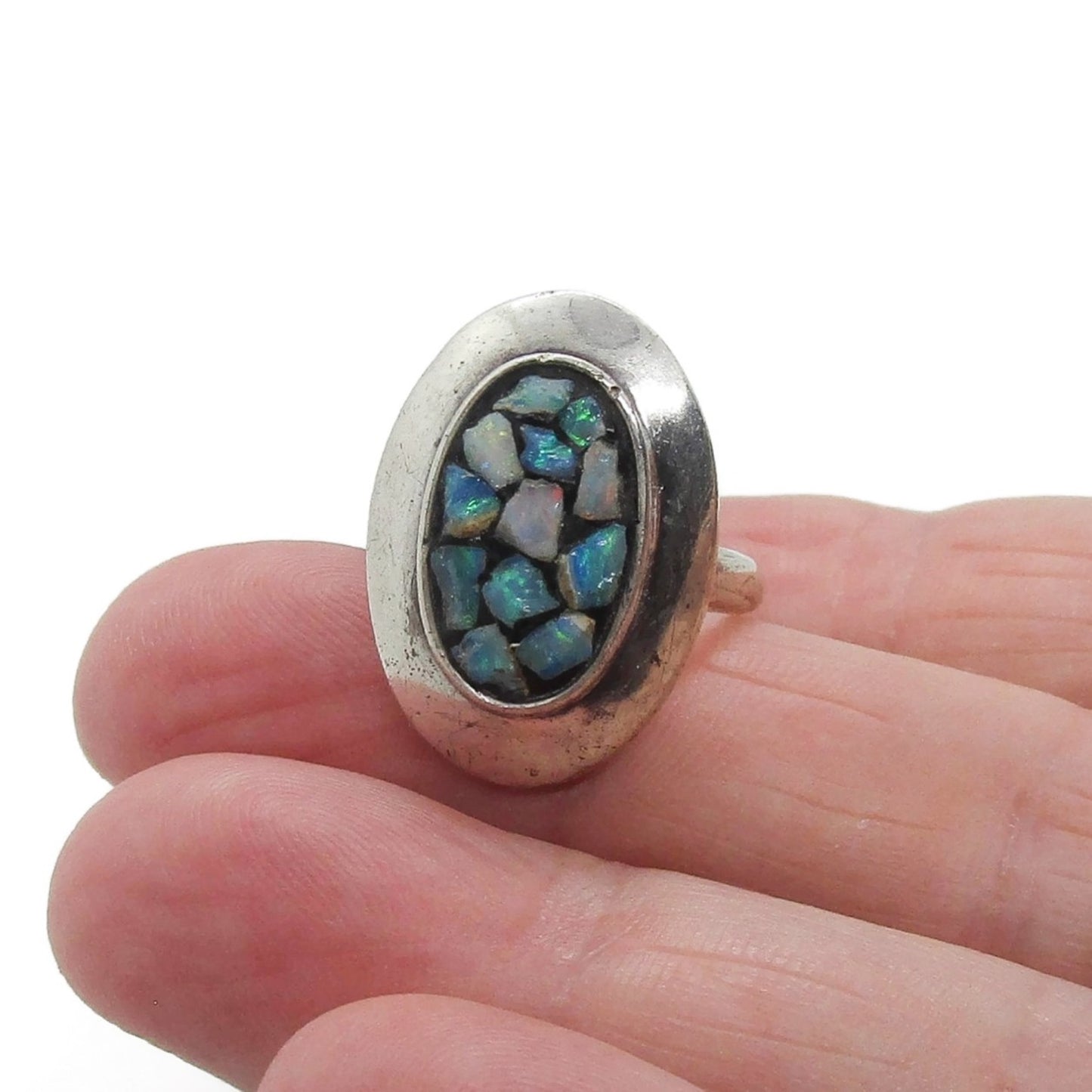 A Scandia Australia sterling silver and opal chip ring shown held in a hand