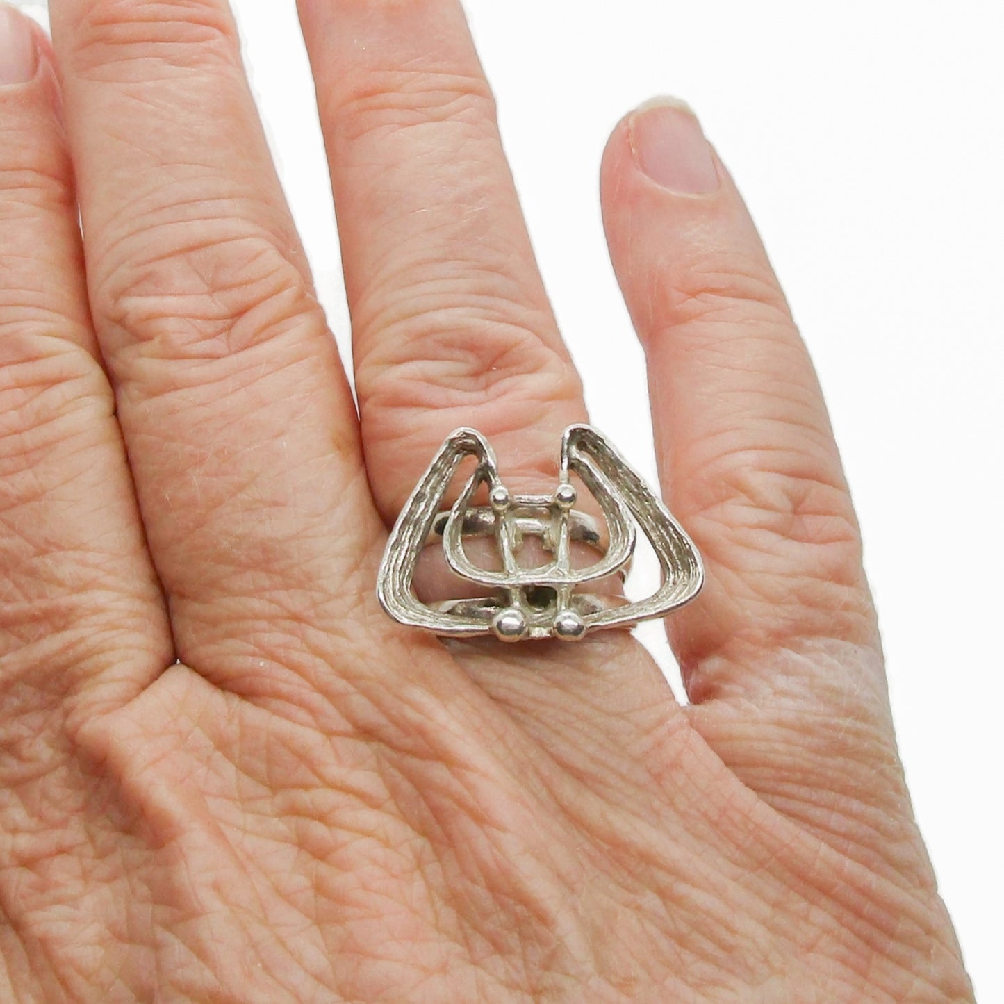A Studio Elsa and Paul Norway sterling silver brutalist ring shown worn on a finger