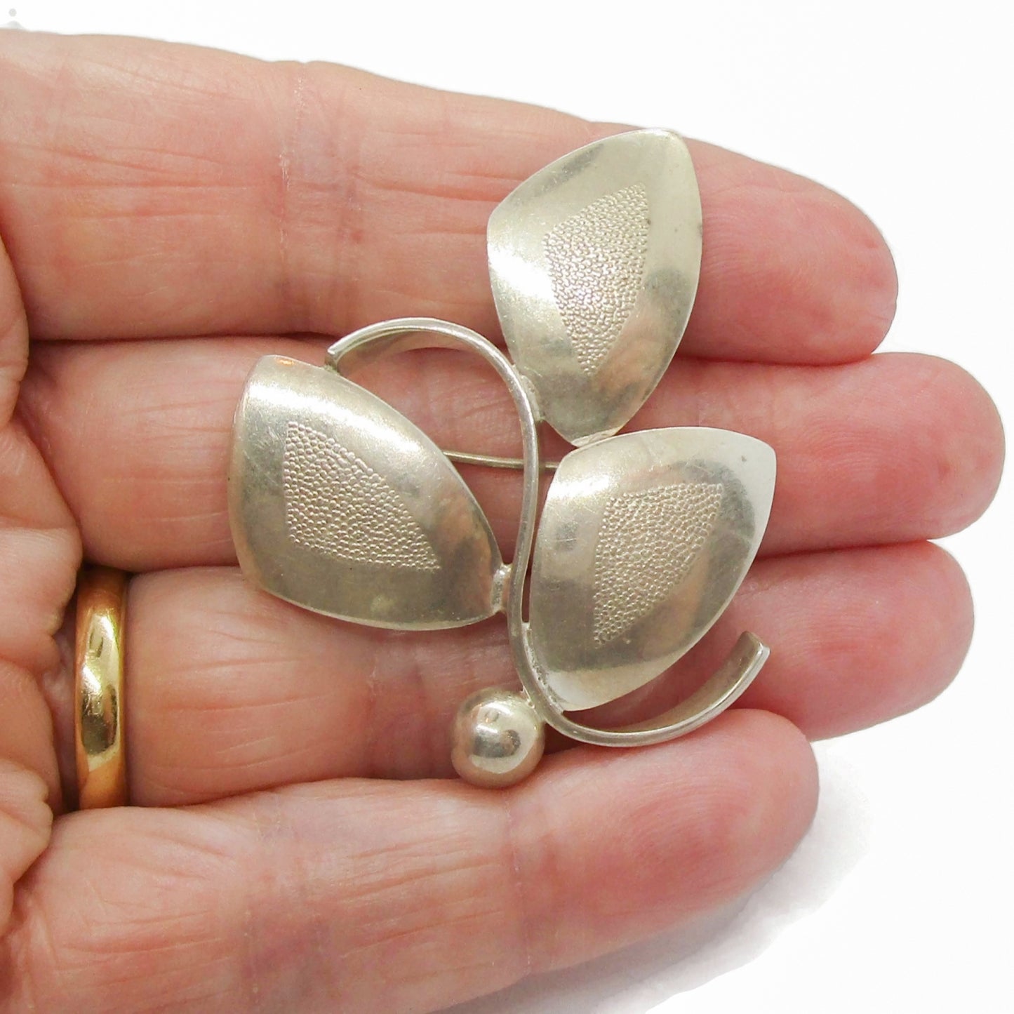 Theodor Skat Rordam Denmark sterling silver brooch shown being held in a hand