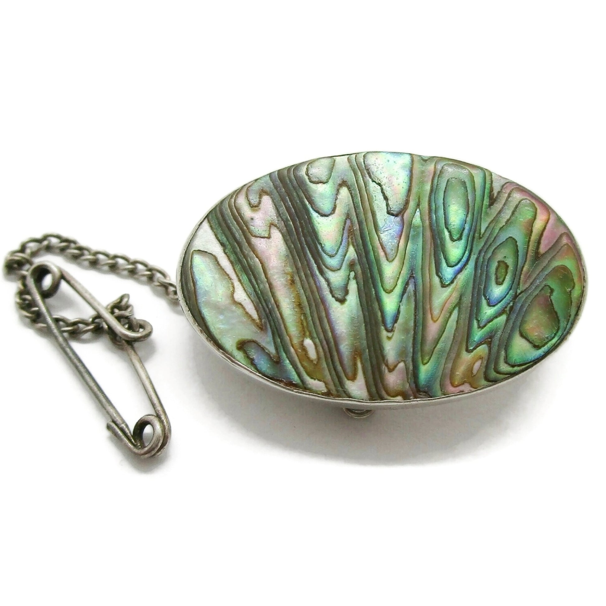 Oval sterling silver and carved paua shell brooch with safety chain front view