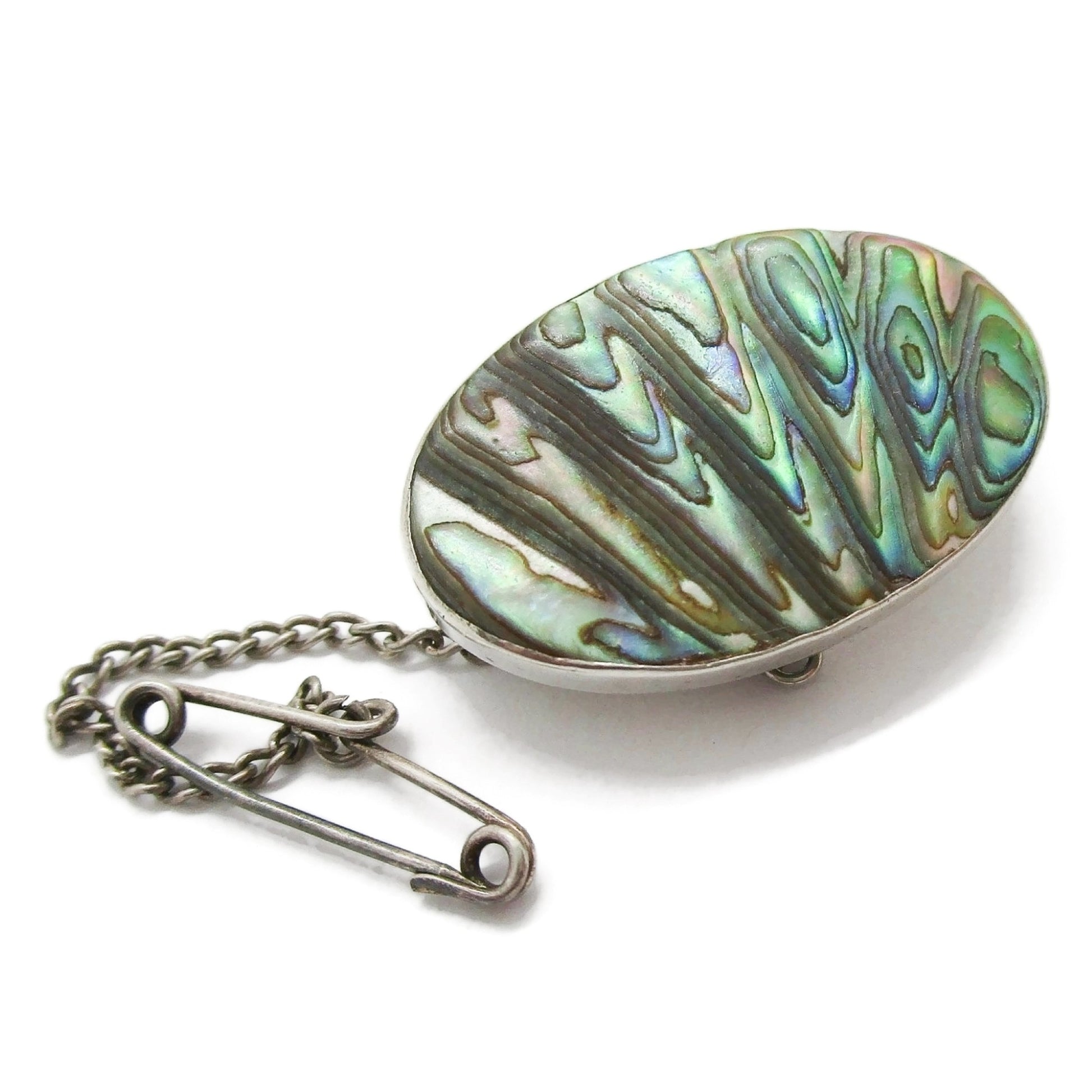 Vintage sterling silver and paua shell brooch with safety chain diagonal view