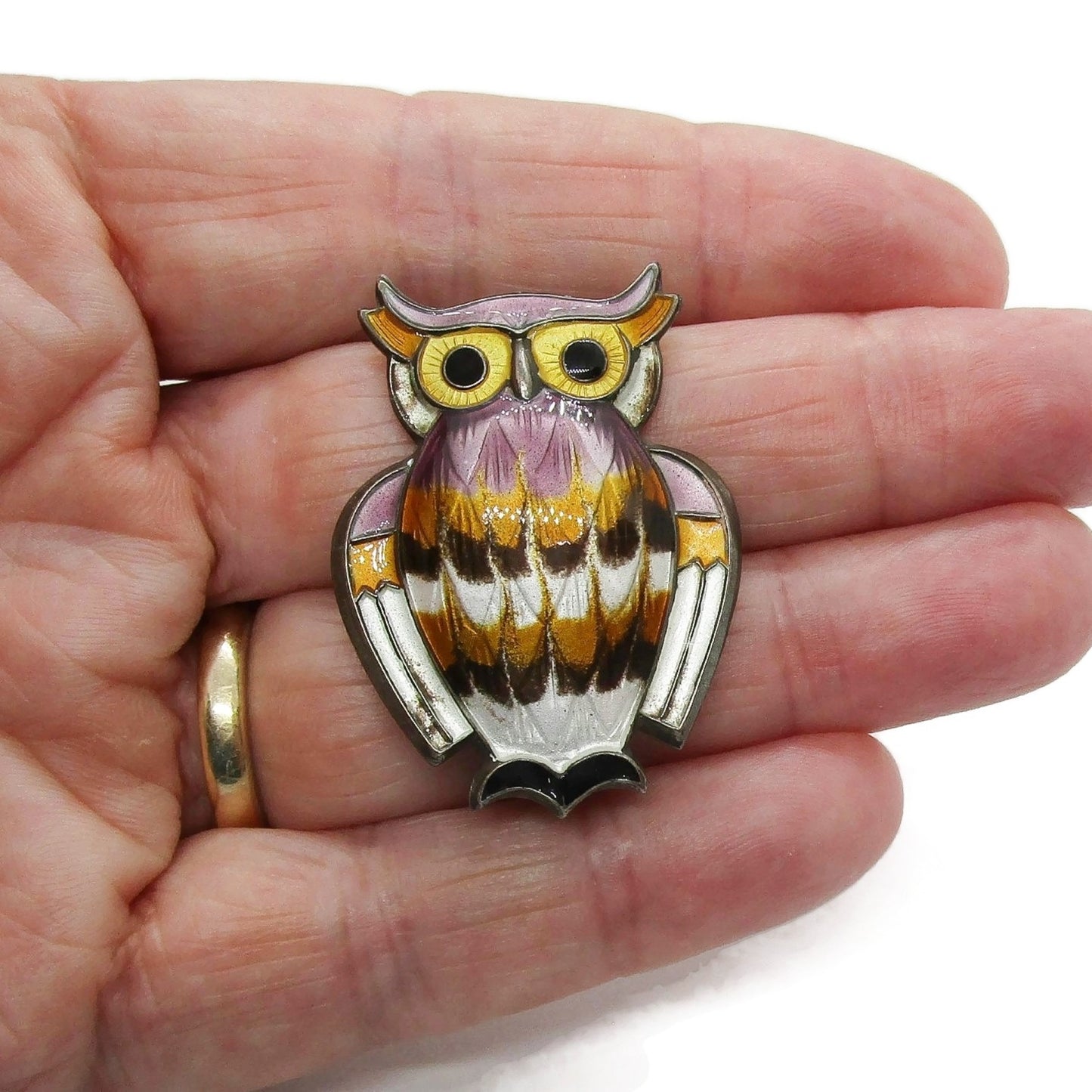 David Andersen sterling silver gilt and enamel owl brooch held in a hand