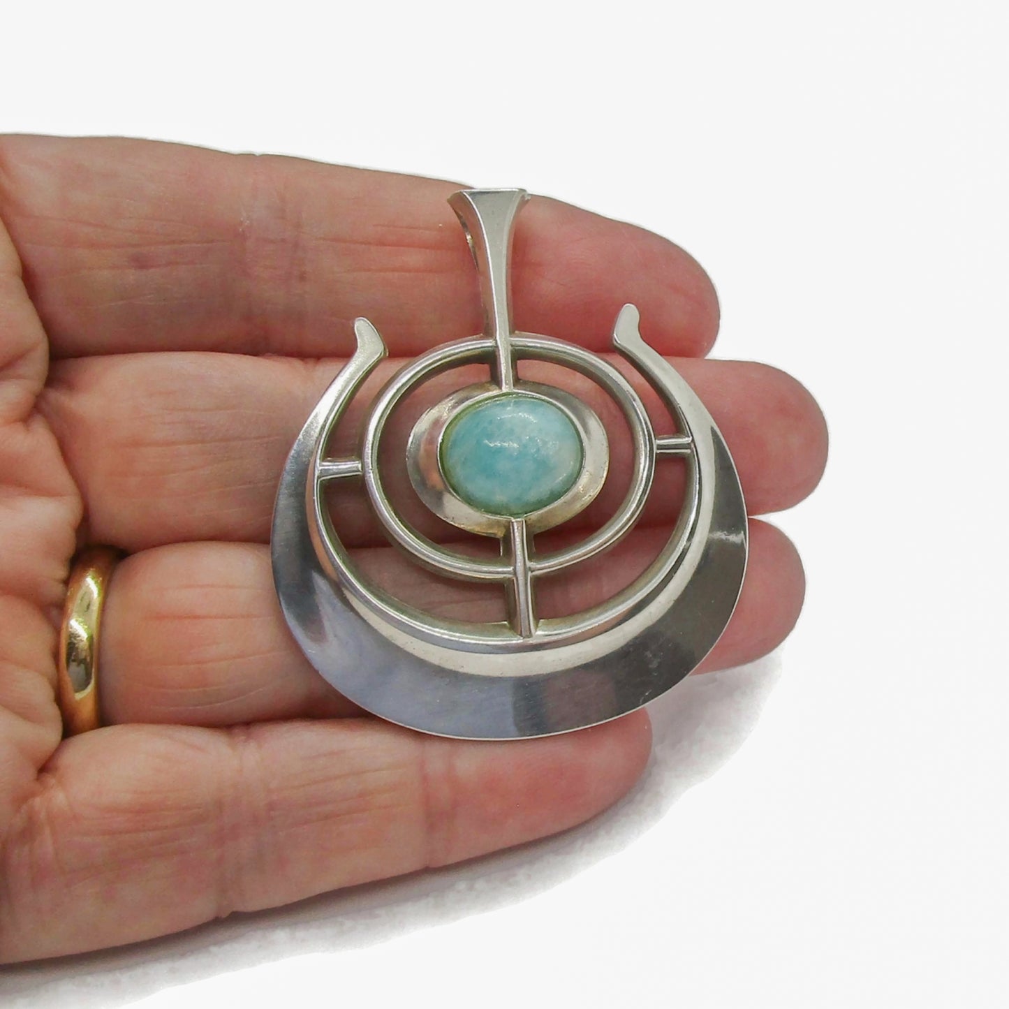 A David Andersen Norway sterling silver and amazonite "Ship of Good Fortune" pendant from the Troll series held in a hand