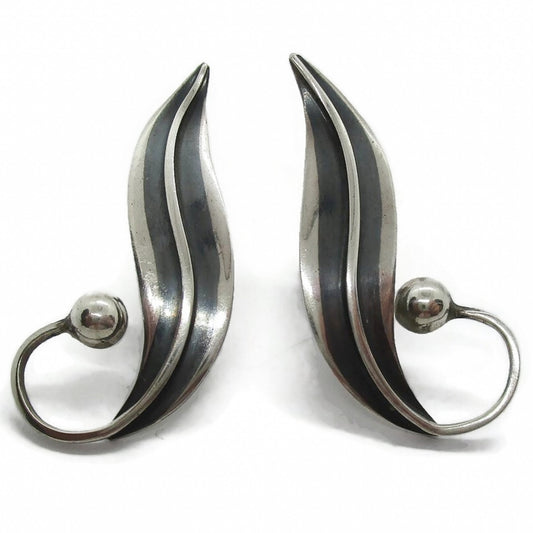 Front view of a pair of sterling silver screw on earrings in a curvy design by Delfino Mexico