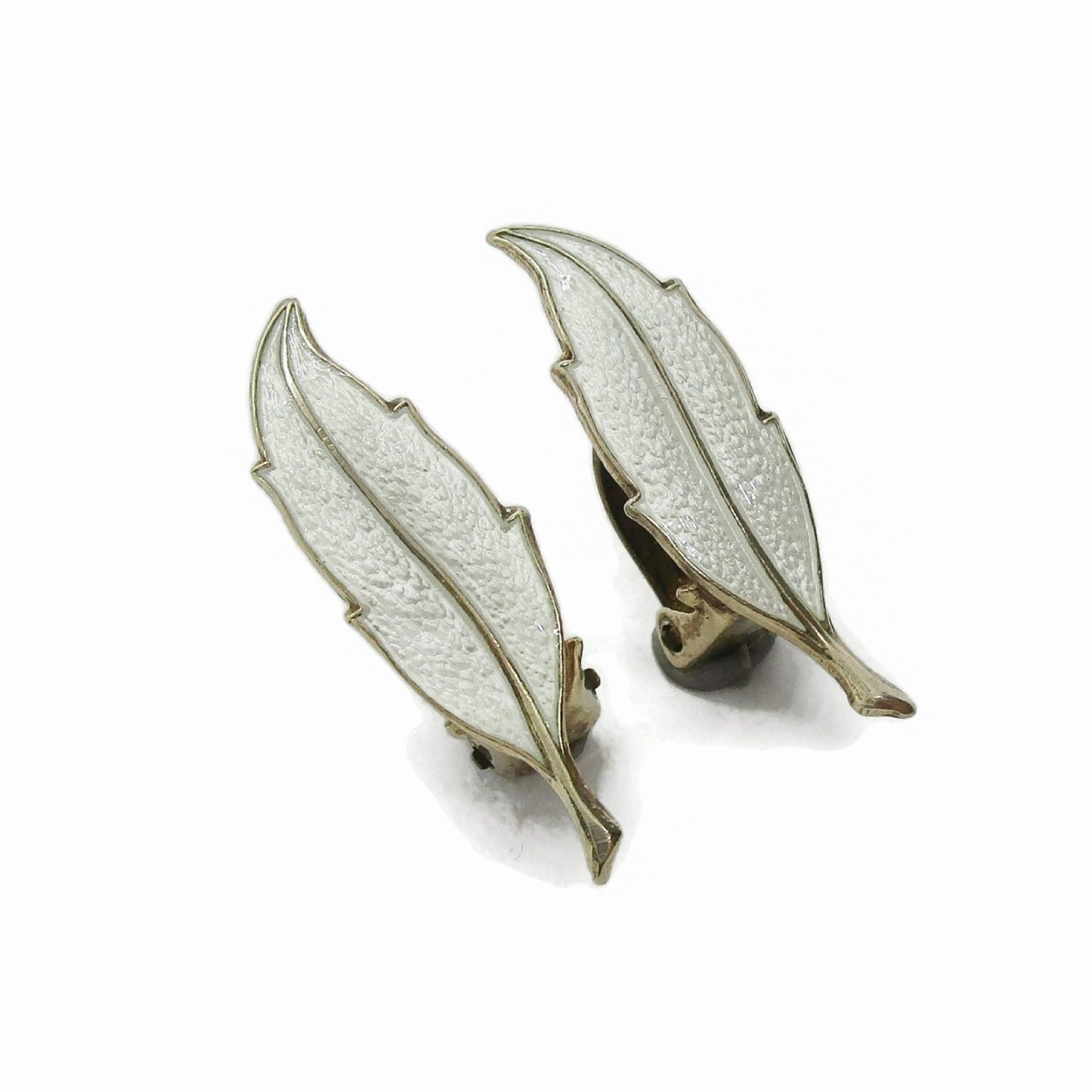 A pair of Finn Jensen Norway sterling silver gilt and white enamel leaf clip on earrings seen from the side