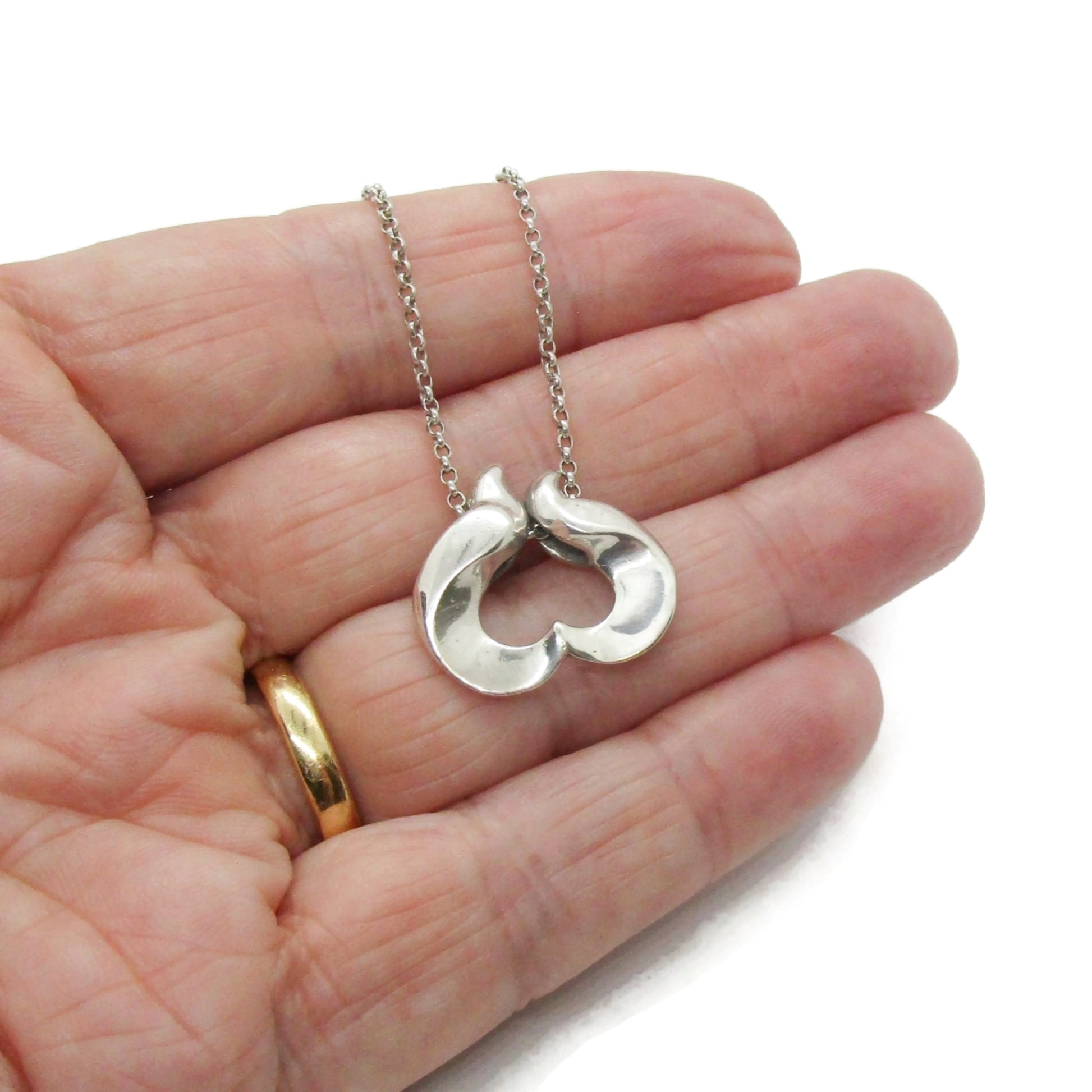 Georg Jensen sterling silver pendant of the year for 1995 designed by Allan Scharff shown held in a hand