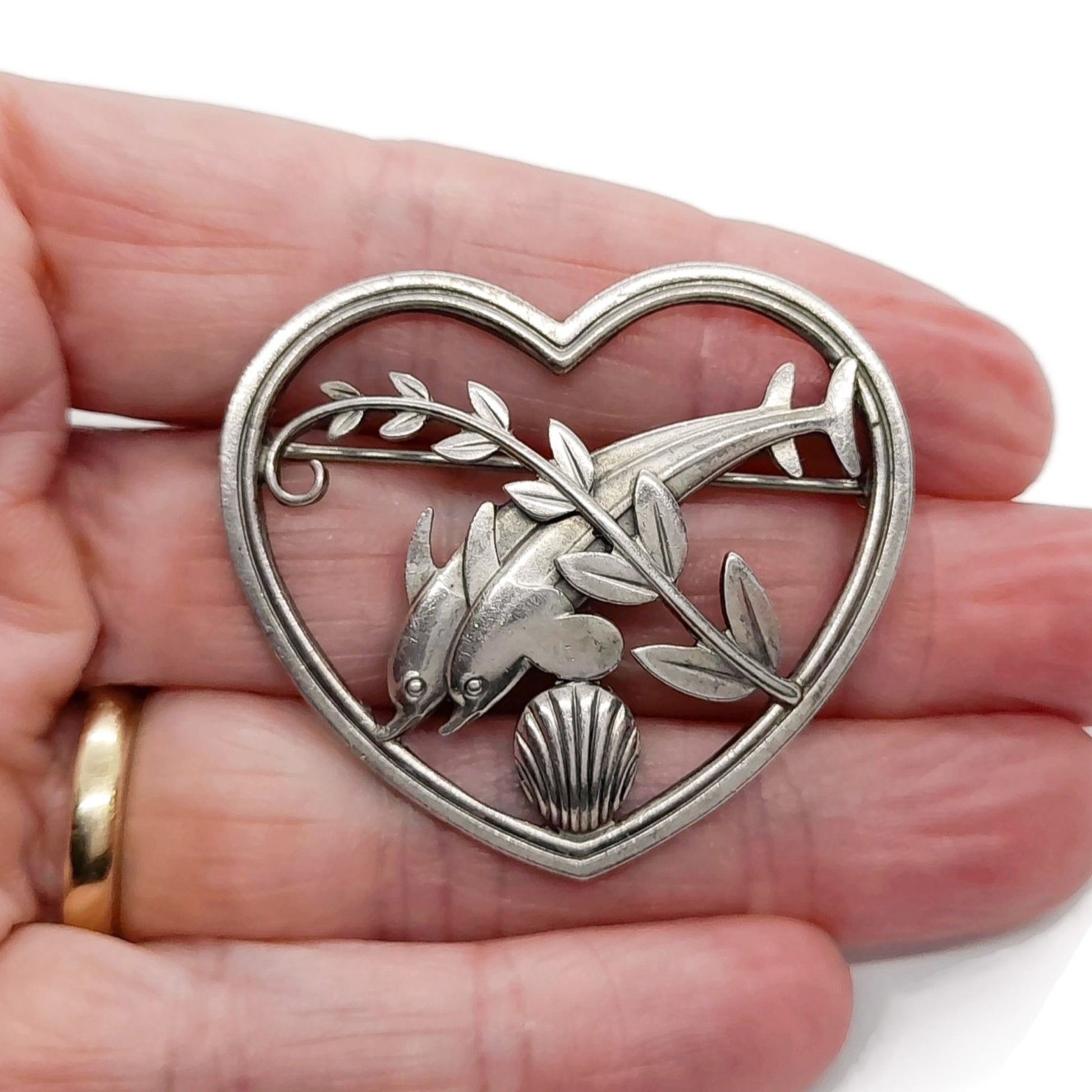 Georg Jensen Denmark sterling silver dolphins in heart brooch shown held in a hand