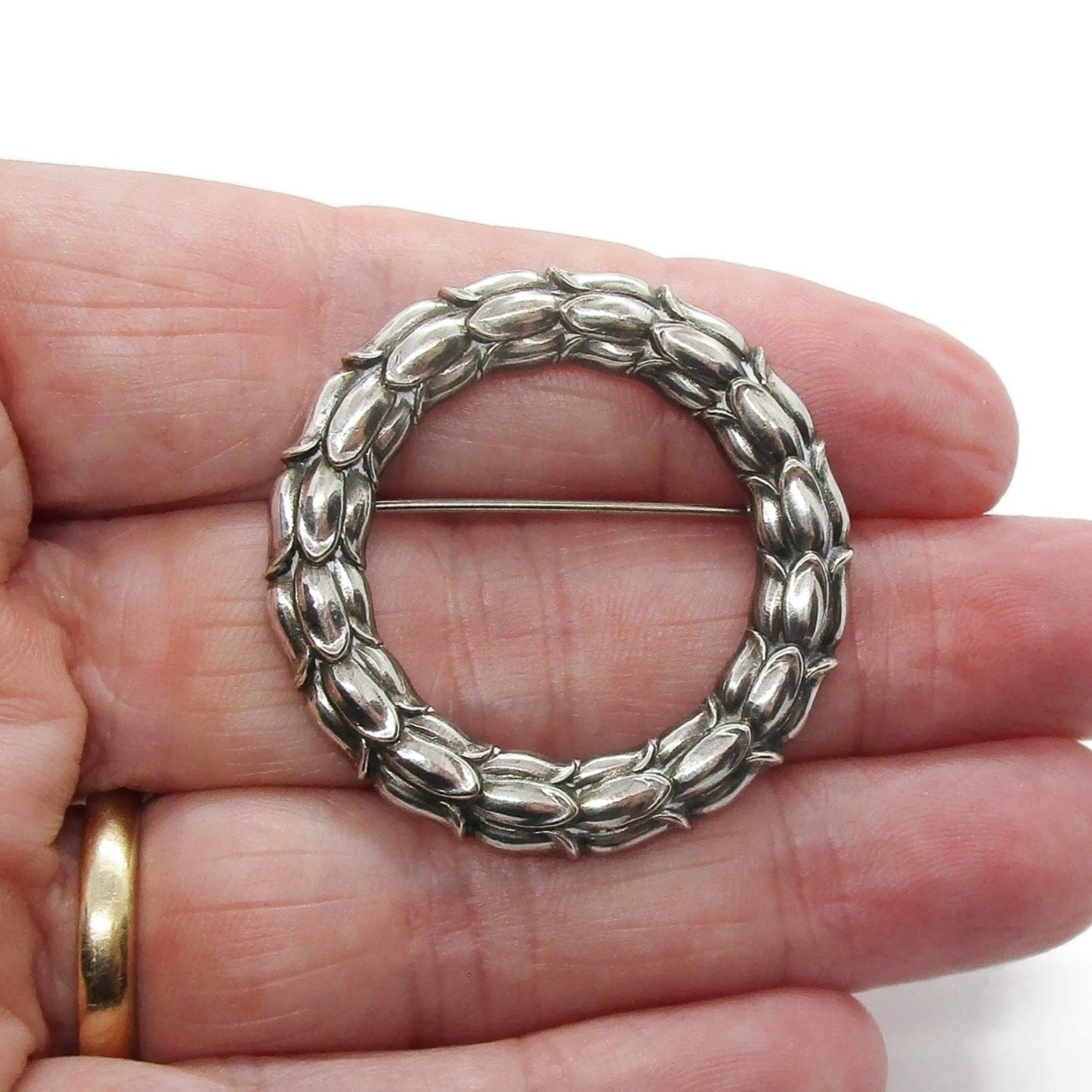 Georg Jensen Denmark sterling silver wreath brooch number 301 shown held in a hand