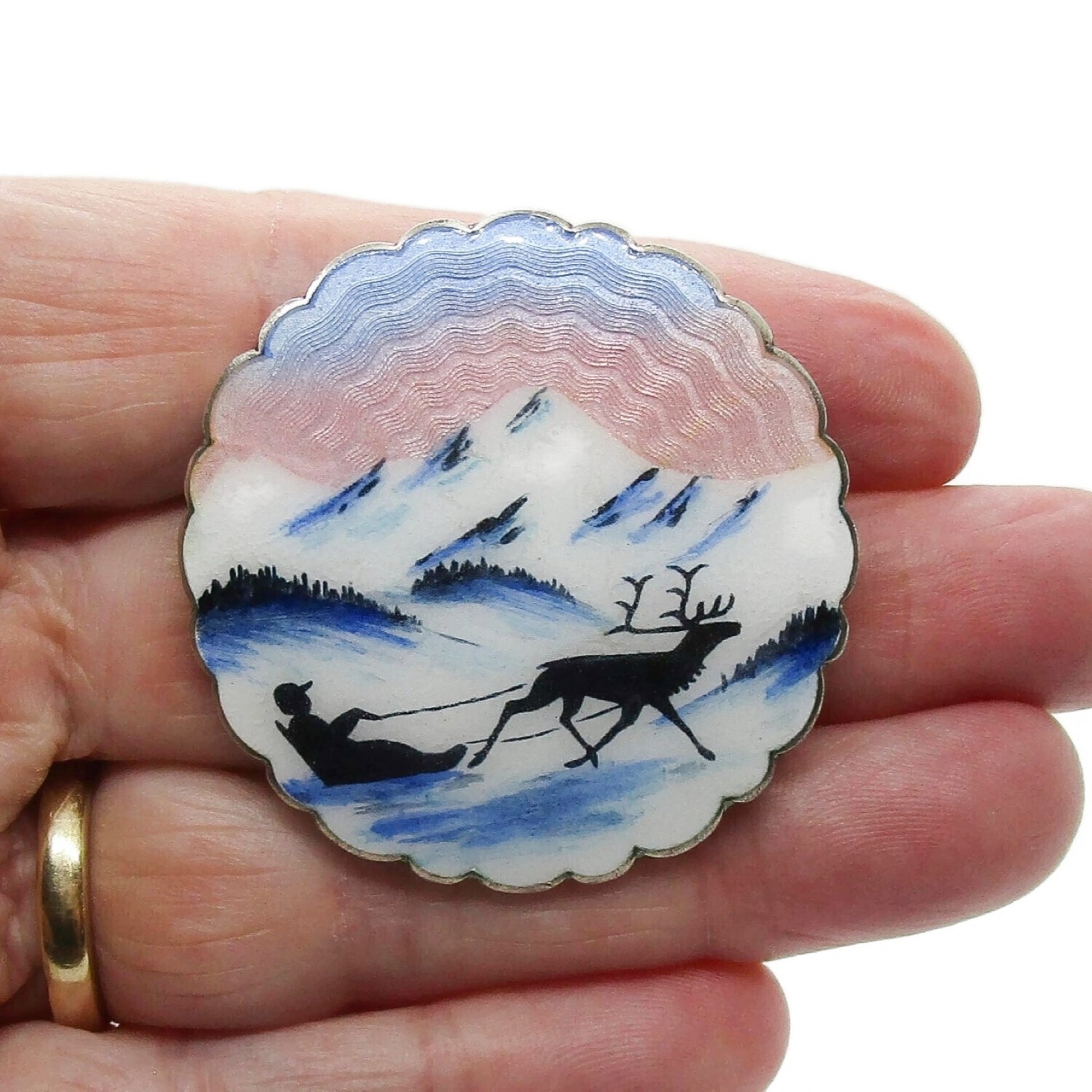 Large Ivar Holth sterling silver and enamel brooch showing man in sled pulled by reindeer held in hand