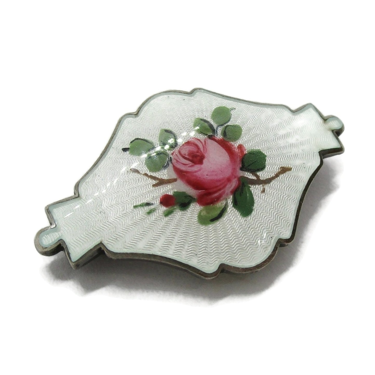 Small shield shaped Ivar Holth Norway sterling silver enamel pink rose brooch shown at an angle
