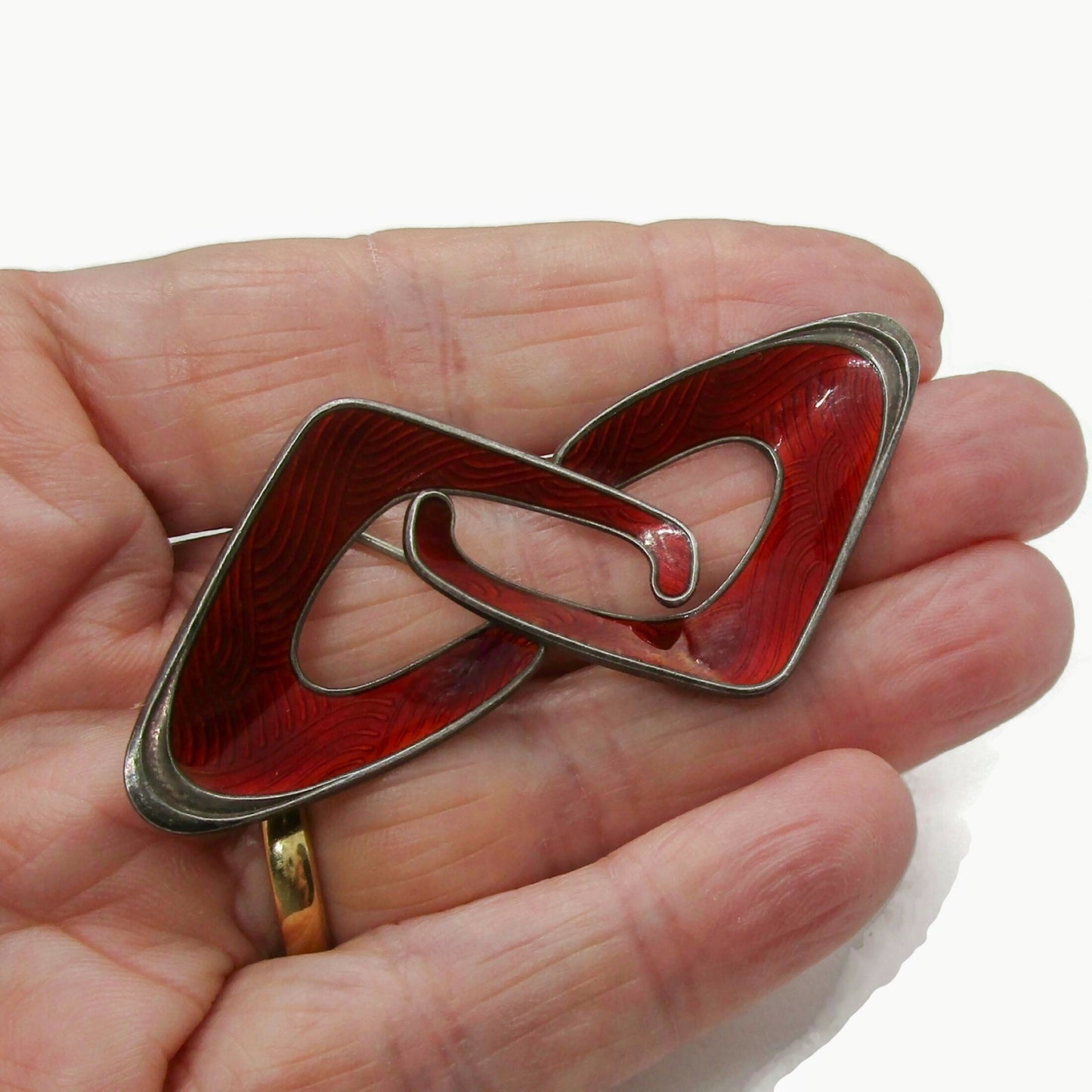 Ivar Holth Norway red enamel and sterling silver abstract brooch shown held in a  hand