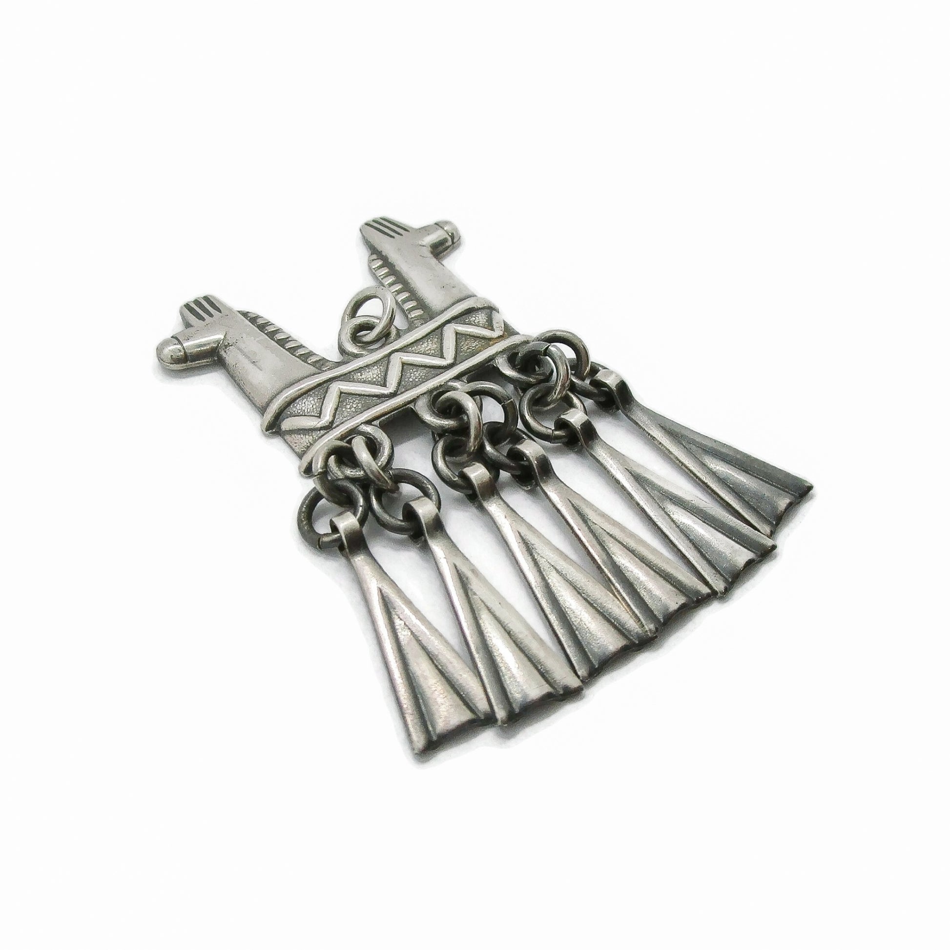 Angled view of a Kalevala Koru Finland sterling silver double headed horse pendant