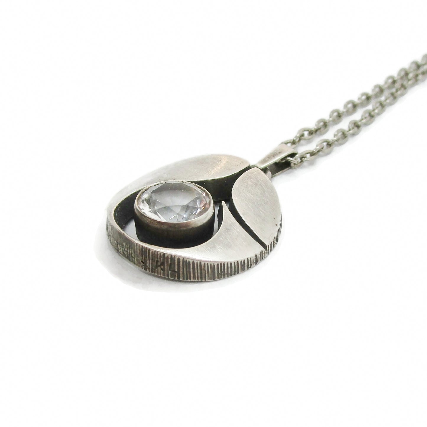 Angled view of a Karl Laine Finn Feelings sterling silver and rock crystal pendant on a chain