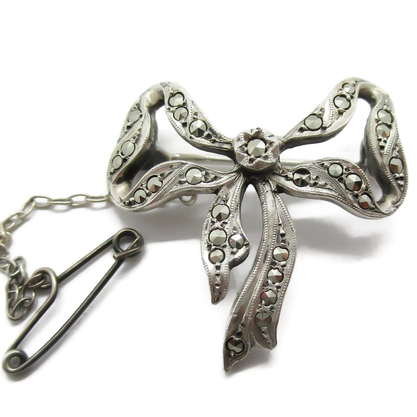 Close up of Lega Australia sterling silver and marcasite bow brooch with safety chain