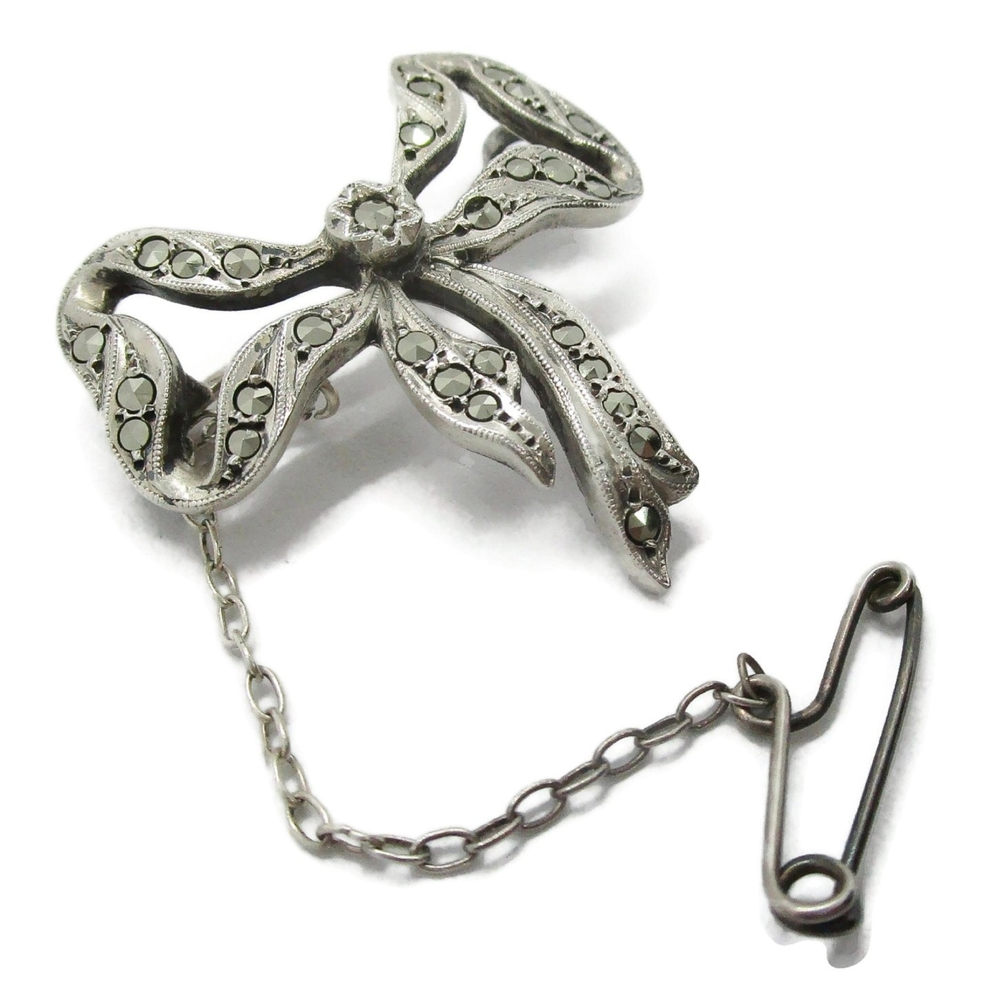 Lega Australia marcasite and sterling silver bow brooch with safety chain shown on an angle