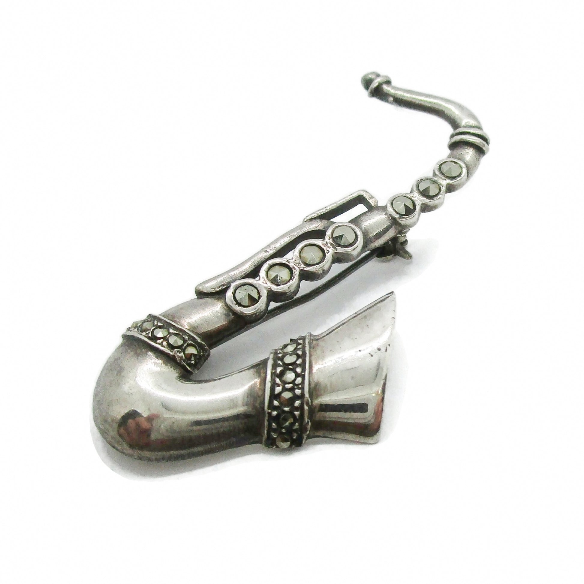 Vintage sterling silver and marcasite saxophone brooch shown on an angle