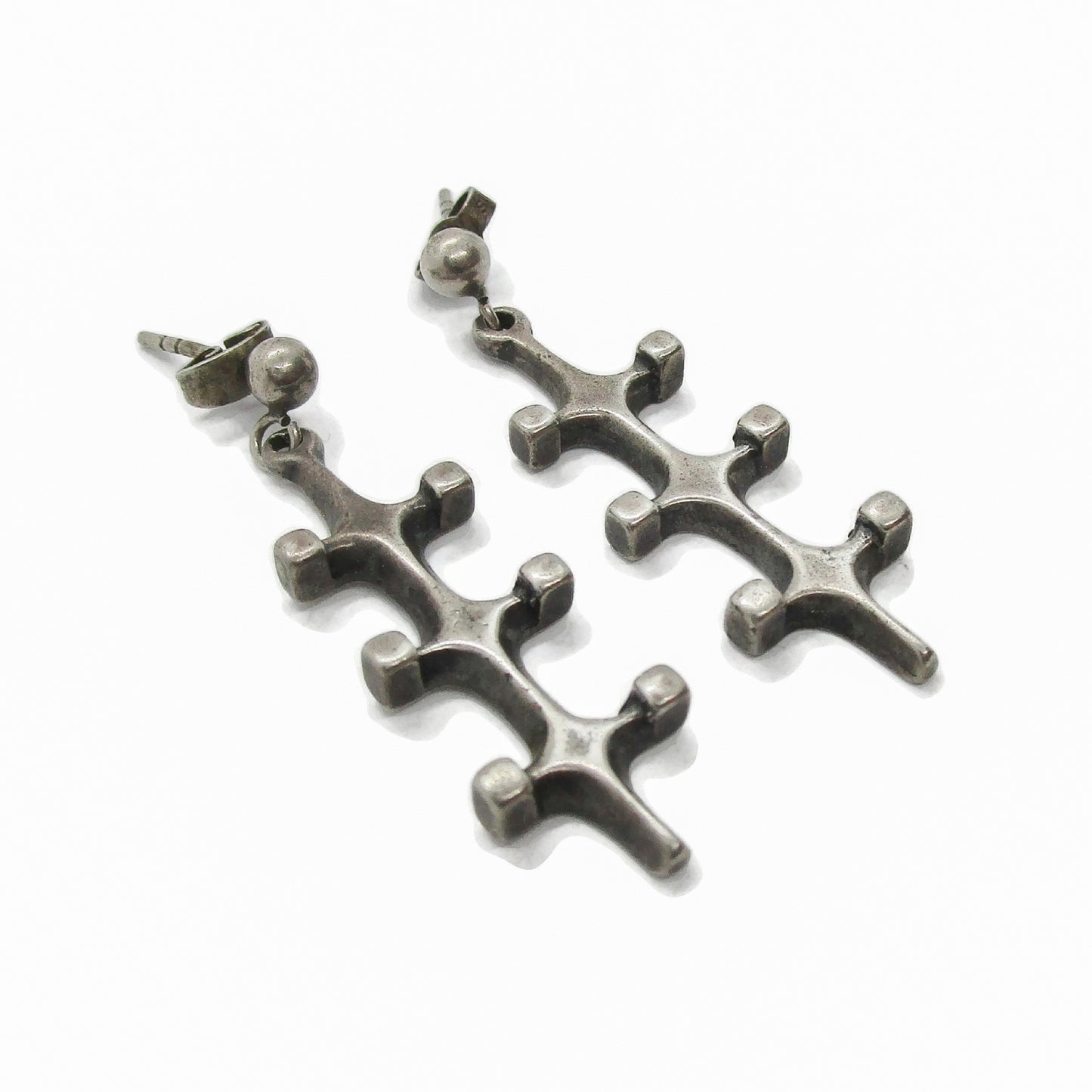 Angled view of a pair of Marianne Berg Troll series sterling silver dangle earrings