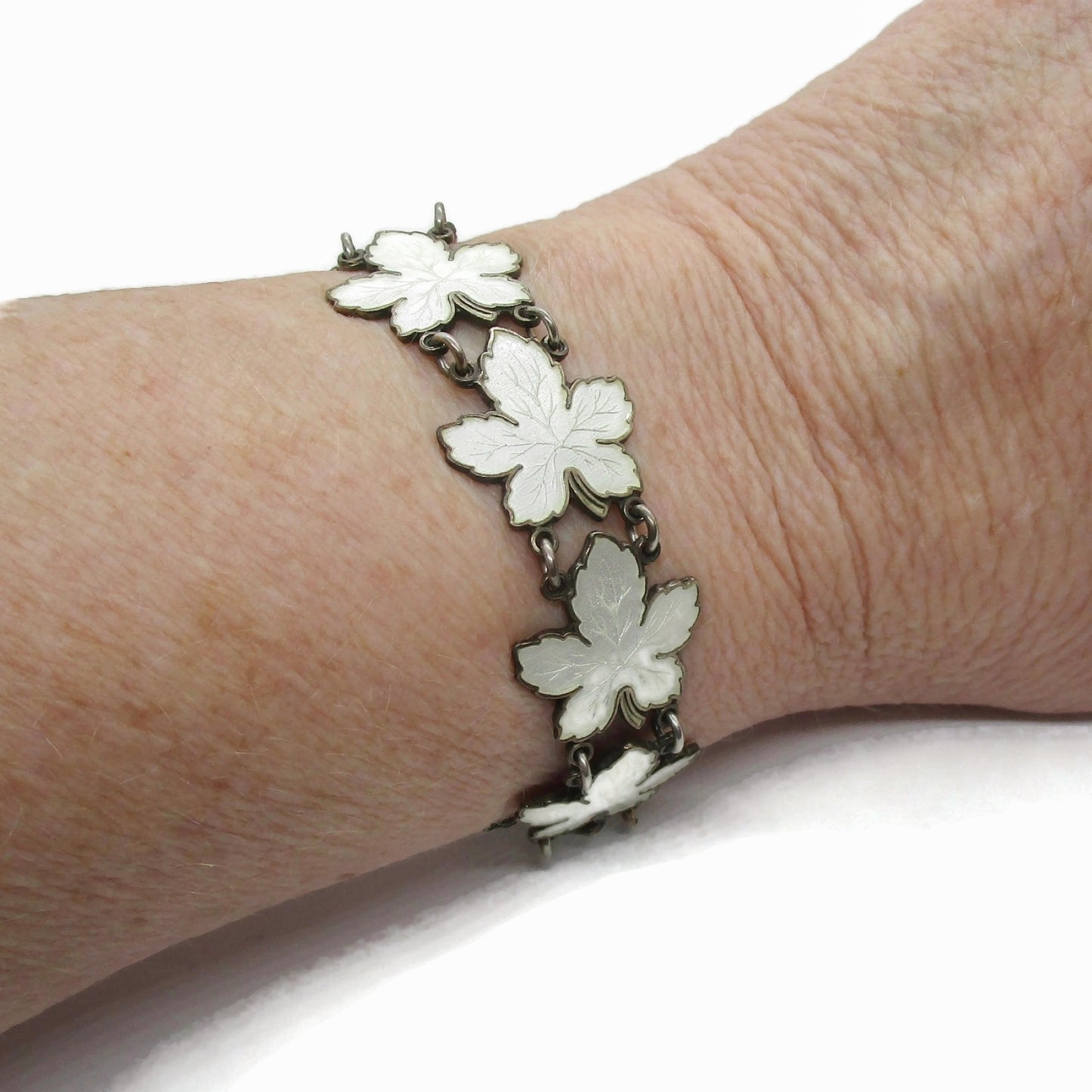 Meka sterling silver and white enamel maple leaf bracelet shown worn on wrist