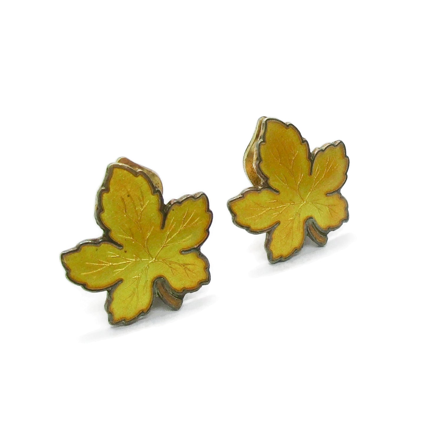 Angled view of a pair of Meka Denmark yellow guilloche enamel and sterling silver gilt maple leaf clip on earrings