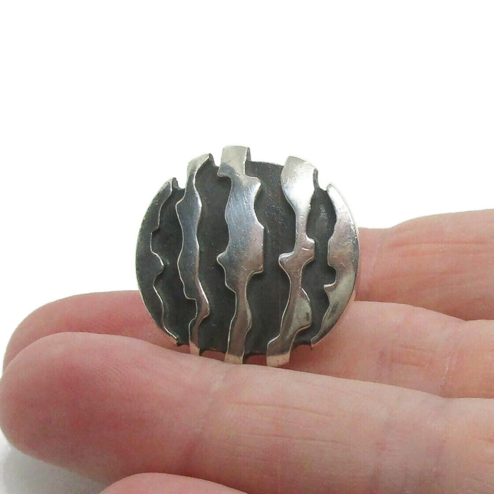 A Niels Erik From Denmark sterling silver brutalist ring shown held in a hand