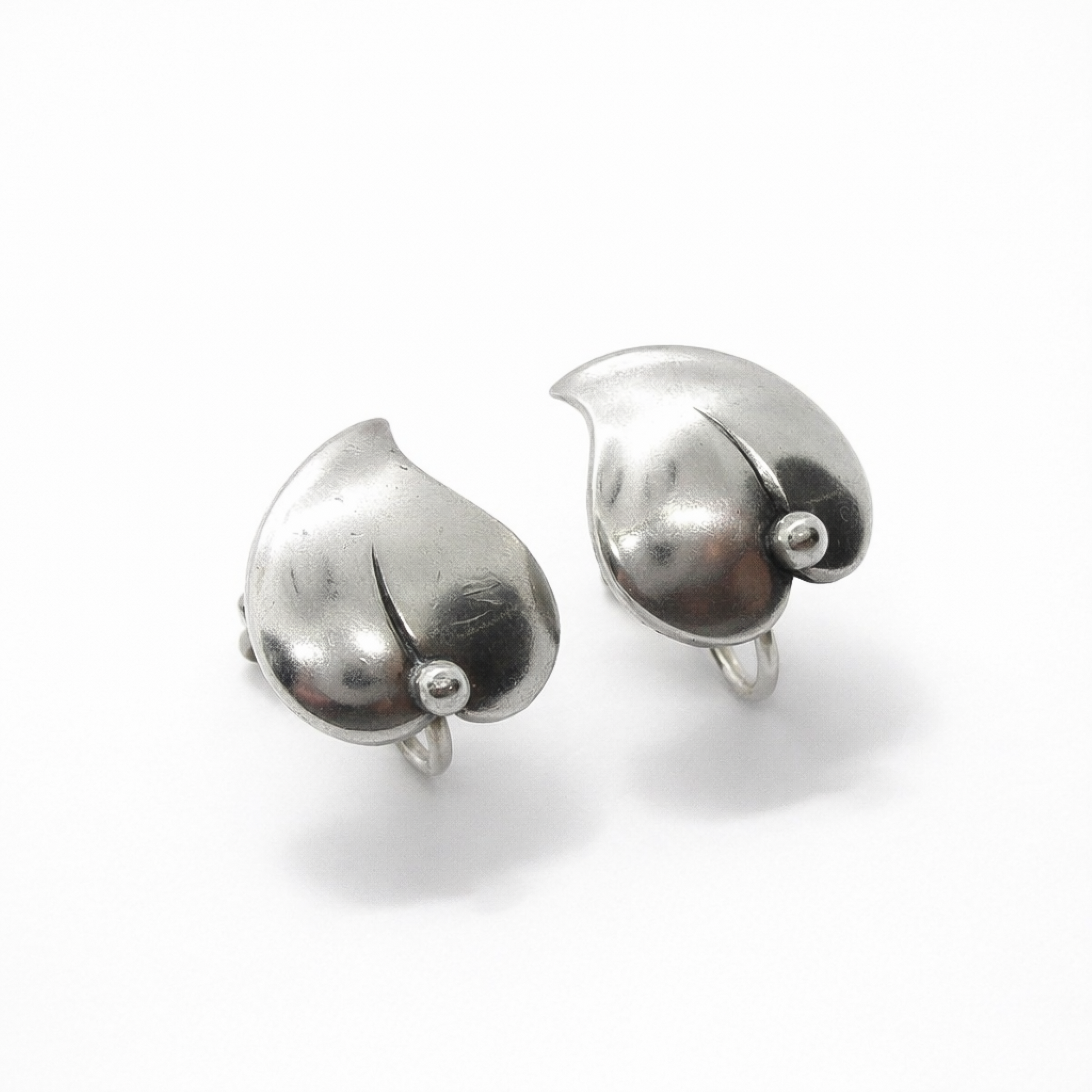 Angled side view of a pair of vintage sterling silver screw back leaf earring by Niels Erik From, Denmark