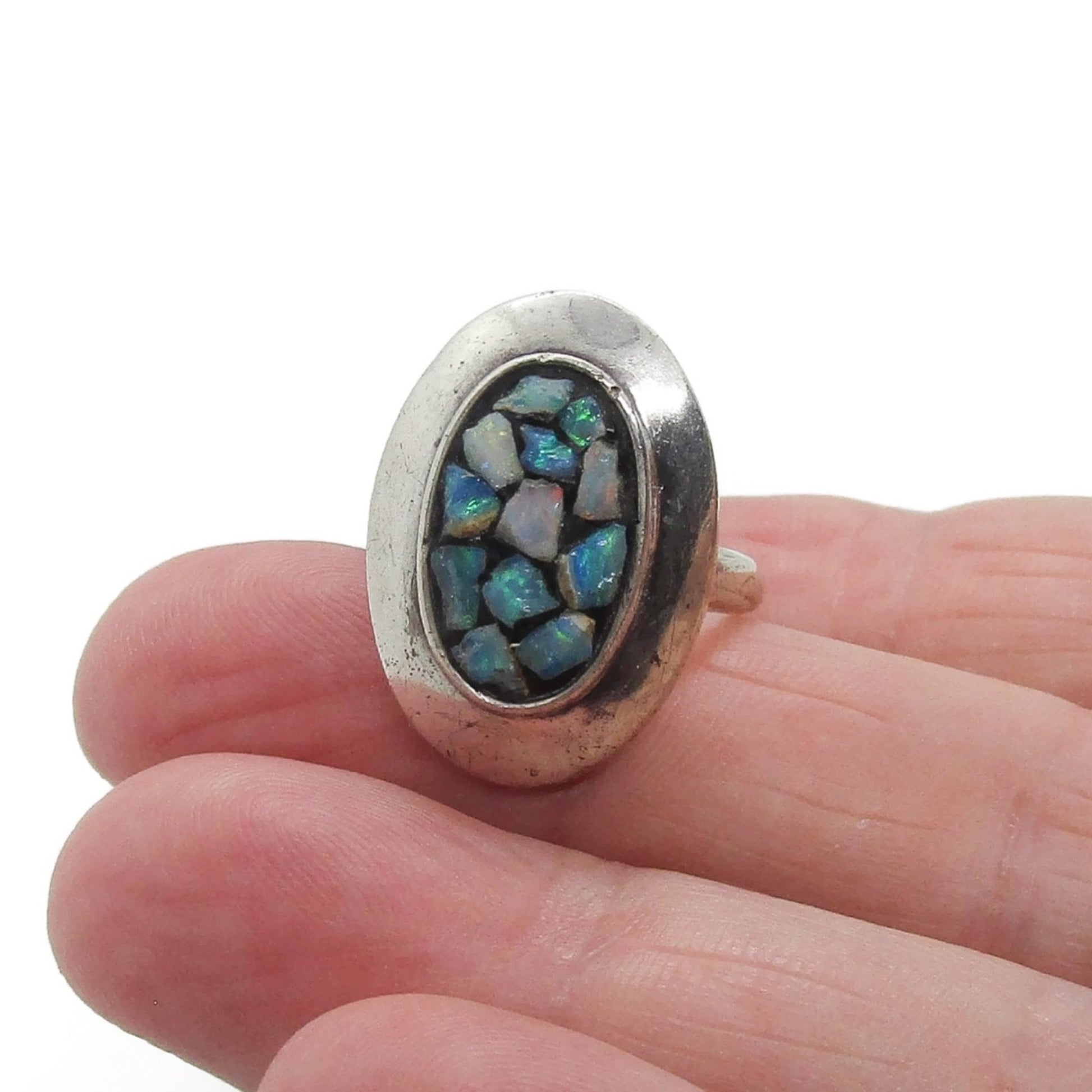 A Scandia Australia sterling silver and opal chip ring shown held in a hand