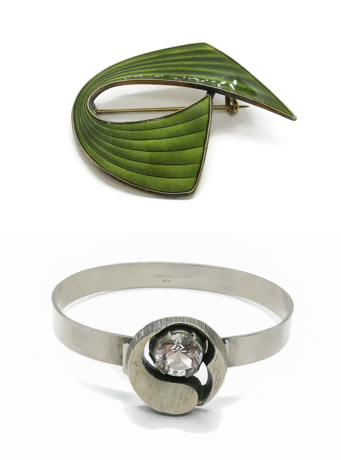 Green enamel brooch and silver bracelet with a central rock crystal on a white background