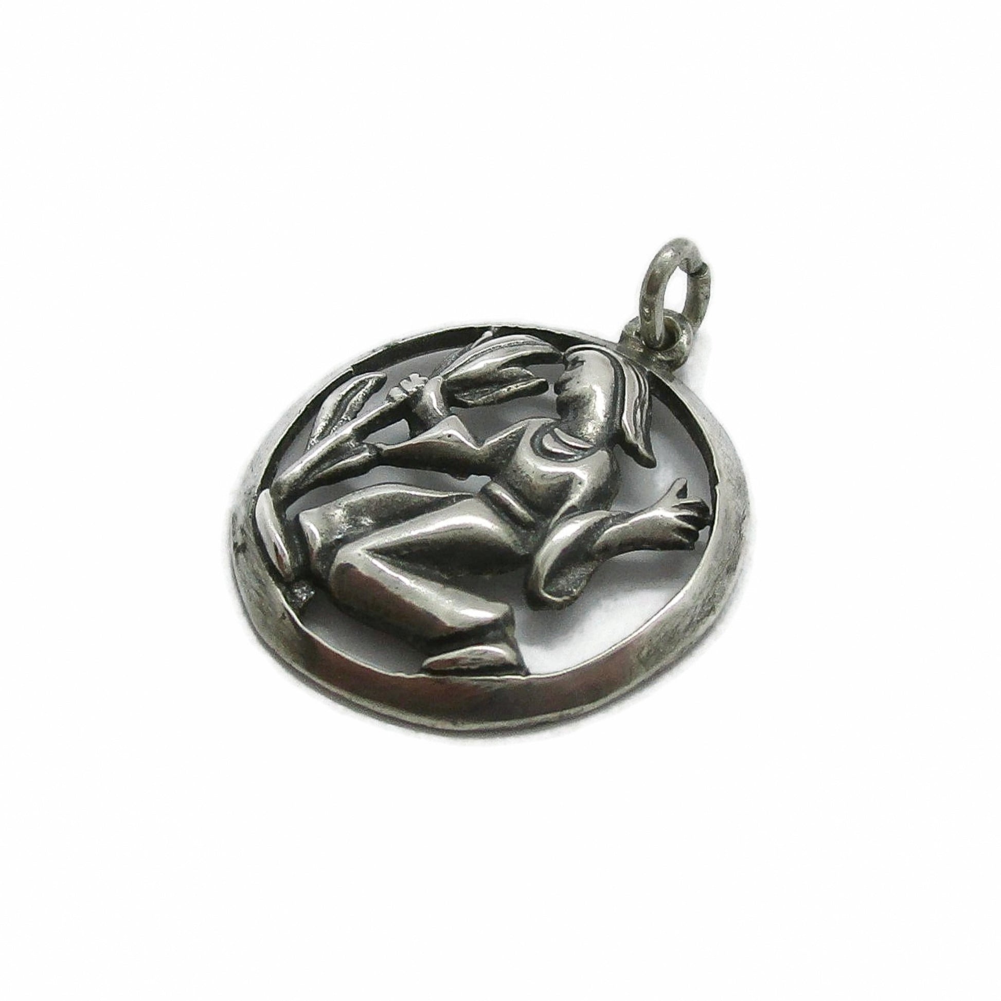 Angled view of a vintage silver Virgo pendant