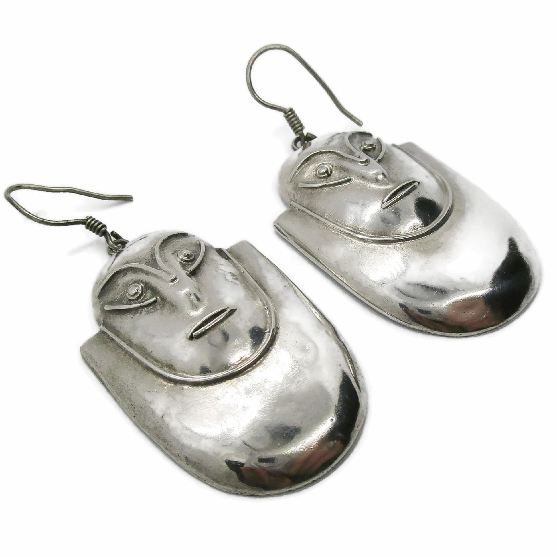Pair of vintage big sterling silver face shaped dangle earrings shown on an angle