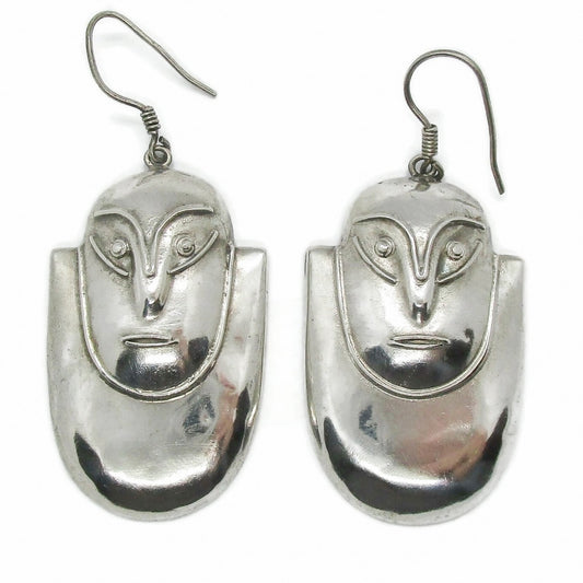 Front view of a pair of vintage big sterling silver face shaped dangle earrings