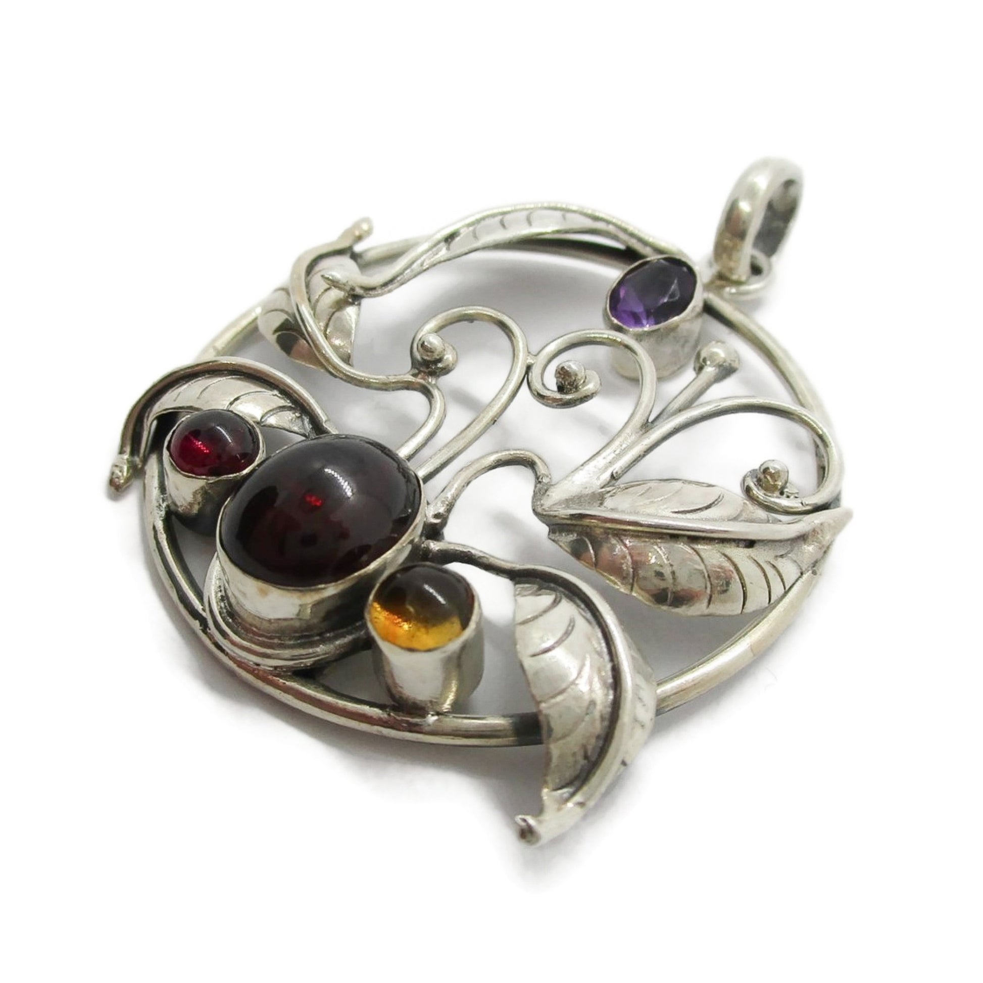 Angled view of a large vintage sterling silver and gemstone floral design pendant