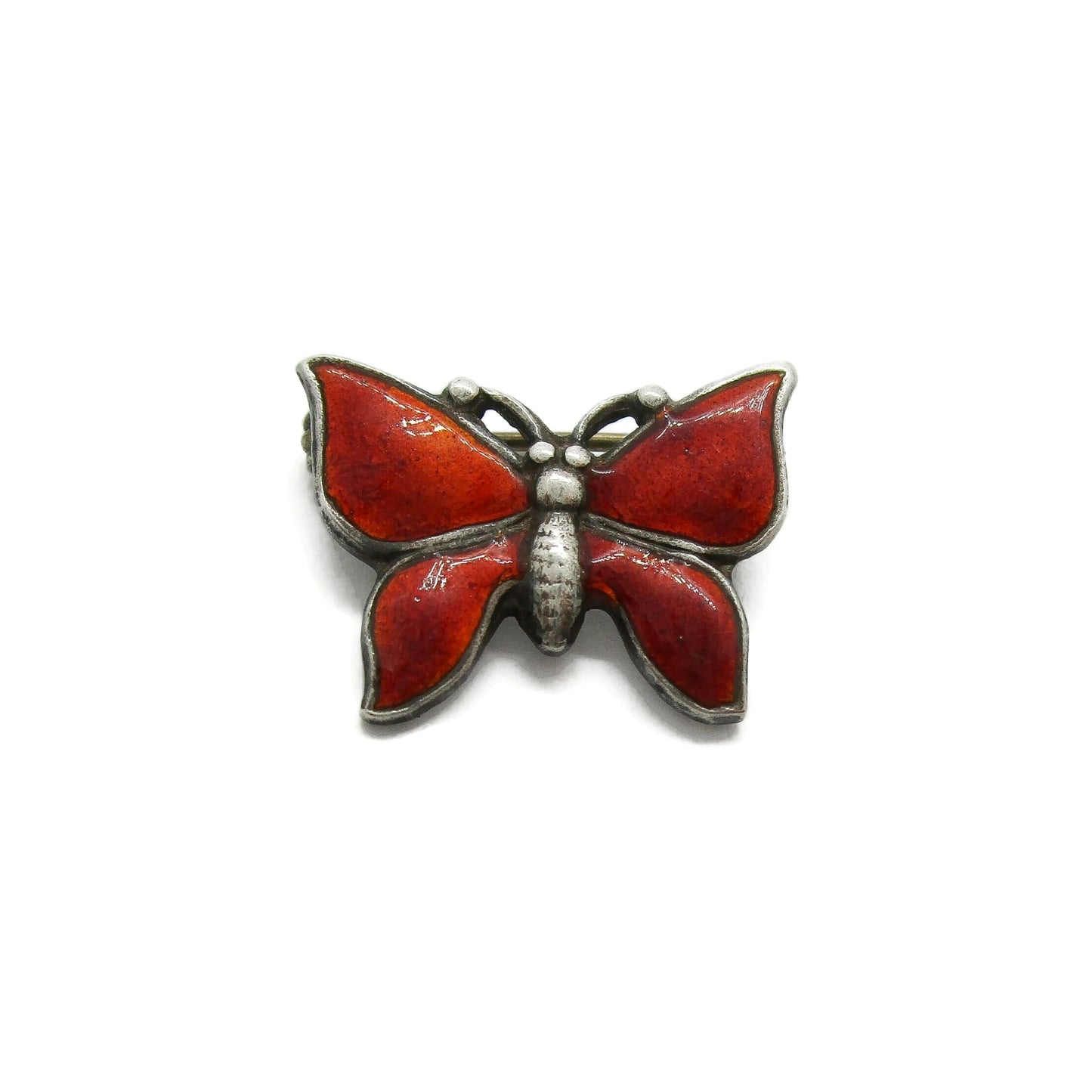 Front view of a small vintage red enamel and sterling silver butterfly brooch