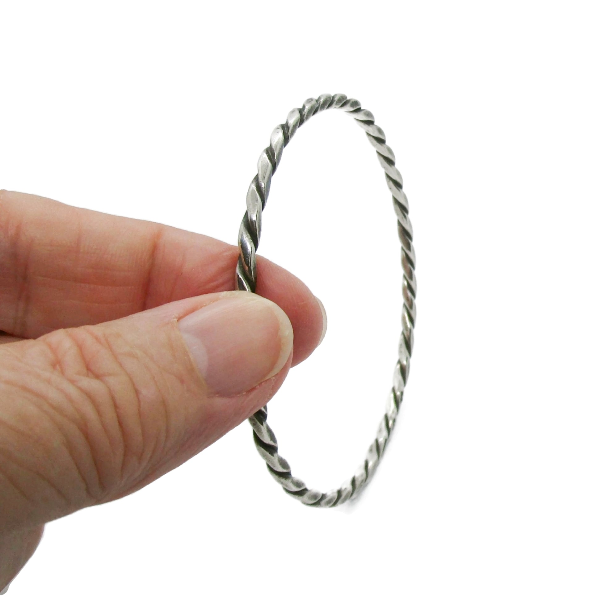 Vintage Randers Solvvefabrik twisted sterling silver bangle being held by two fingers