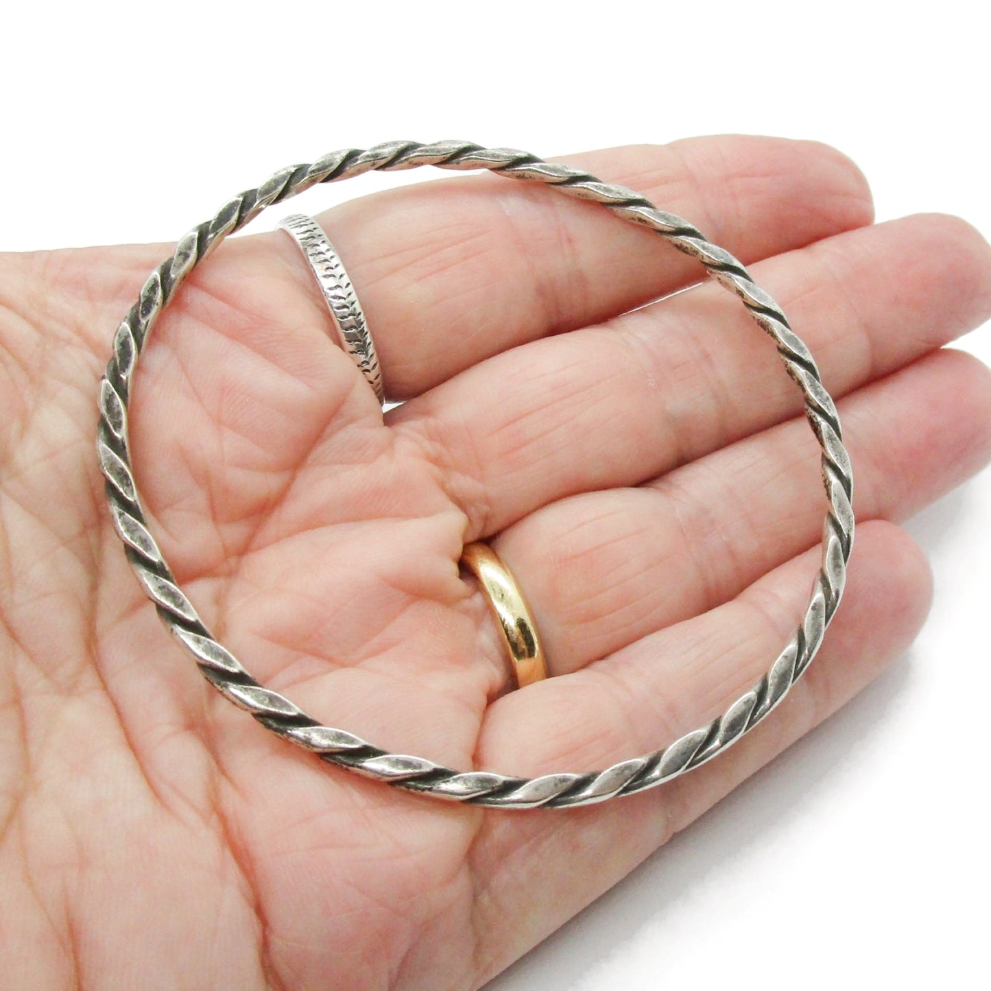 Vintage Randers Solvvefabrik twisted sterling silver bangle lying flat in the palm of a hand